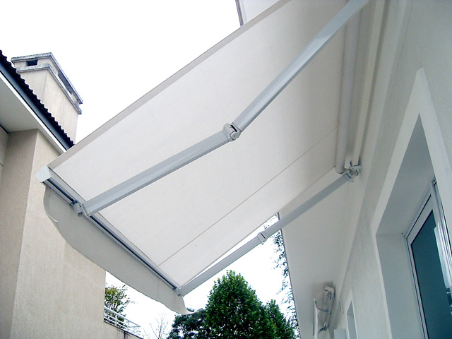 Toldo articulado instalado em uma fachada residencial